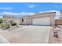 Charming single-story home featuring a tile roof, two car garage, and a paver driveway at 5517 Meridian Rain St, North Las Vegas, NV 89031