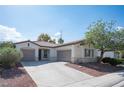 Inviting home with a two-car garage, a well-kept lawn, and desert landscaping under a bright sky at 6333 Sterling Ranch Way, North Las Vegas, NV 89081