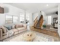 Bright living room with neutral tones, tile flooring, staircase, and comfortable seating arrangement at 6636 Surfbird St, North Las Vegas, NV 89084
