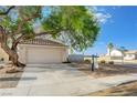 Lovely single-story home with two-car garage and desert landscaping with a mature shade tree at 7528 Golden Yucca Dr, Las Vegas, NV 89147