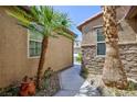 Walkway flanked by stucco and stone walls and desert landscaping at 7609 Slide Rock Ave, Las Vegas, NV 89113