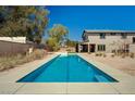 Backyard featuring long rectangular in-ground pool with desert landscaping and a glimpse of the house at 7736 Tioga Ridge Ct, Las Vegas, NV 89117