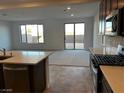 Kitchen with island and stainless-steel appliances; sliding glass doors offer view of the backyard at 8020 Texas Hills St, Las Vegas, NV 89113