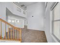 Bright living room featuring two-story ceilings and neutral carpeting at 8529 Gold Flash Ave, Las Vegas, NV 89129