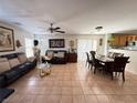 Inviting living room with tile flooring, comfortable sofas, and an adjacent dining area at 8898 Promised Land Ave, Las Vegas, NV 89148