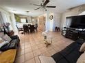 Spacious living room with neutral tile flooring, comfortable seating, and a ceiling fan at 8898 Promised Land Ave, Las Vegas, NV 89148
