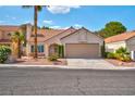 Charming single-story home boasts a tile roof and a two-car garage, enhanced by mature landscaping and a well-maintained lawn at 9116 Cypress Point Way, Las Vegas, NV 89117