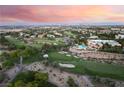 An elevated view of a sprawling community with manicured golf courses and luxurious homes against a beautiful horizon at 912 Pro Players Dr, Las Vegas, NV 89134