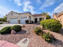 Inviting single-story stucco home with a three-car garage and desert landscaping at 9728 Echo Hills Dr, Las Vegas, NV 89134