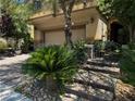 Inviting home exterior featuring stone accents, a brick driveway, and lush landscaping at 10526 Harvest Wind Dr, Las Vegas, NV 89135