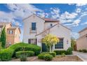 Two-story home featuring landscaped yard, garden, and tile roof under beautiful sky at 10987 Santorini Dr, Las Vegas, NV 89141