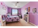 Bright bedroom with purple walls, a ceiling fan, and a window offering natural light at 1204 Moselle Ct, Las Vegas, NV 89144