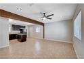 Spacious living room features beamed ceiling and modern ceiling fan, with tile flooring and ample natural light at 125 S 15Th St, Las Vegas, NV 89101