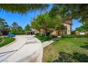 View of lush green lawn and landscaping leading to the front of this spacious home with a circular driveway at 1345 Morning Sun Way, Las Vegas, NV 89110