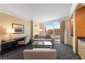 Bright living room with beige walls, comfortable seating, a desk, and a large window offering city views at 2000 N Fashion Show Dr # 2704, Las Vegas, NV 89109
