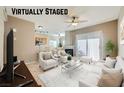 Staged living room with neutral colors, a white sofa, a fireplace, and a sliding glass door for outdoor access at 2108 Calville St # 104, Las Vegas, NV 89128