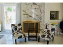 Cozy sitting area with floral chairs, stylish marble fireplace, and natural light streaming through the doors at 2659 Vegas Valley Dr, Las Vegas, NV 89121