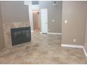 Open-concept living room featuring a tile fireplace, neutral walls, and tile flooring at 3116 Gentle Breeze St, Las Vegas, NV 89108