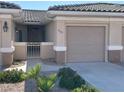 Inviting home exterior with a neutral color palette, landscaped yard, and charming gated courtyard entrance at 3161 Quail Song Dr # 3161, Laughlin, NV 89029