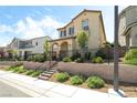 Charming two-story home with a landscaped front yard, black fence, and stairs leading to an arched doorway at 3641 Portici Ln, Henderson, NV 89044