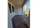 Cozy covered front patio with stone flooring and natural light, perfect for outdoor seating and relaxation at 3654 Stoppani Ave, Henderson, NV 89044