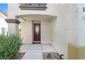 Close-up of the front door featuring a decorative glass insert, with drought-tolerant landscaping at 3689 Bufflehead St, Las Vegas, NV 89122