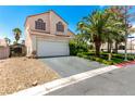 Two-story home featuring a well-maintained front yard with a mature palm tree and desert landscaping at 3825 Manhattan Bridge Pl, North Las Vegas, NV 89032