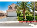 Two-story home featuring a well-maintained front yard with a mature palm tree and green lawn at 3825 Manhattan Bridge Pl, North Las Vegas, NV 89032