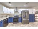 Modern kitchen featuring stainless steel appliances, granite countertops, and blue and white cabinets at 4428 Los Reyes Ct, Las Vegas, NV 89121