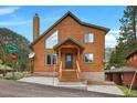 Charming two-story cabin with a green roof nestled in a mountain setting with a street view at 4830 Silver Tip Way, Mount Charleston, NV 89124