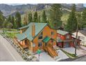Inviting two-story cabin with a green roof and deck, nestled in a mountain setting with a street view at 4830 Silver Tip Way, Mount Charleston, NV 89124