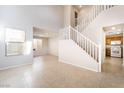 Bright entryway featuring tile floors, staircase and views into the kitchen and living spaces at 5641 Vassar Meadow St, Las Vegas, NV 89148