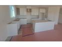 Bright kitchen featuring white cabinets, an island, and natural light from a window at 5736 Remy Rain St, Las Vegas, NV 89148