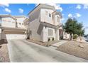 The exterior showcases a spacious driveway leading to an attached garage, complimented by desert landscaping at 5967 Aimless St, Henderson, NV 89011
