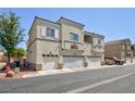 Exterior shot of condo building with garage, balconies, and well-kept landscaping at 6170 E Sahara Ave # 1076, Las Vegas, NV 89142