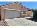 Single-story home with neutral stucco, a two-car garage, and a concrete driveway with brick trim at 8900 Big Bear Pines Ave, Las Vegas, NV 89143