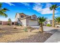 Beautiful exterior view of the home showing the desert landscaping, rock mulch, and a two car garage at 1068 African Eagle Ave, Henderson, NV 89015