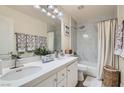 Well-lit bathroom featuring double sinks, granite countertop, tiled shower/tub, and modern fixtures at 11074 Caramel Crest Ct, Las Vegas, NV 89135