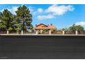 Inviting home with secure wrought iron fencing, mature trees, and a well-manicured lawn, offering privacy and charm at 1385 Morning Sun Way, Las Vegas, NV 89110