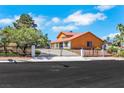 Attractive home featuring a secure gated entrance and lush green landscaping, creating a private and inviting ambiance at 1385 Morning Sun Way, Las Vegas, NV 89110