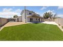 Expansive backyard features lush artificial grass, fenced perimeter, and covered patio at 1511 Irene Dr, Boulder City, NV 89005