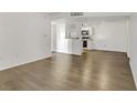 Open-concept living space with hardwood flooring leading into kitchen with white cabinetry at 2120 Ramrod Ave # 1318, Henderson, NV 89014