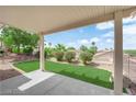 Spacious covered patio overlooks a meticulously landscaped backyard with verdant turf and desert flora at 2504 Libretto Ave, Henderson, NV 89052