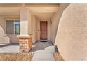 Close-up of a welcoming front door with decorative brick accents on the porch at 261 Via Morelli, Henderson, NV 89011