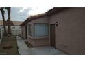 Single-Gathering home side view with a gravel yard and access to the back yard through an iron gate at 2777 Beaconfalls Way, Las Vegas, NV 89142