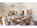 Elegant dining room with a large wooden table, chandelier lighting, and custom cabinets creates a luxurious dining experience at 2793 Red Arrow Dr, Las Vegas, NV 89135