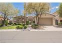 Inviting single-story home featuring lush landscaping, a stone facade, and a convenient two-car garage at 3042 Soft Horizon Way, Las Vegas, NV 89135