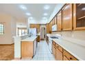 Well-lit kitchen equipped with white appliances, ample counter space, and wood cabinets for storage at 3640 Snowy Pines St, Las Vegas, NV 89147