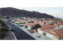 Charming neighborhood streetscape showcasing well-maintained homes with desert landscaping and scenic mountain views at 390 Montego Ln, Boulder City, NV 89005