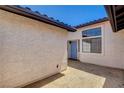 View of the stucco exterior with light-blue front door and windows allowing natural light into the home at 445 Intrepid Ct, Boulder City, NV 89005